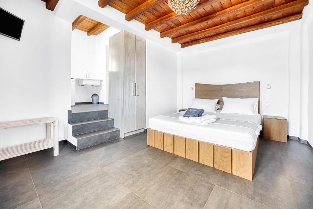 a bedroom with a bed with white sheets and wooden ceilings at Belvedere in Livadi