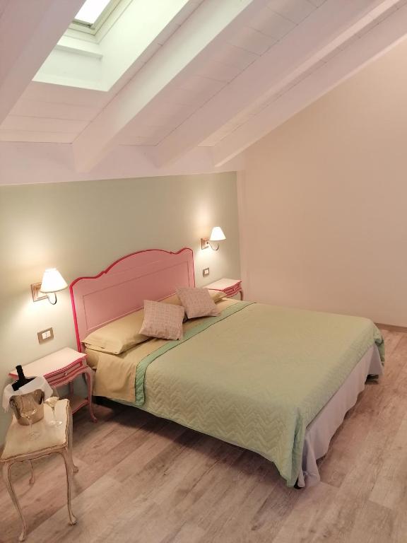 una camera con un grande letto e un soffitto bianco di La Bella Vite a Moncalvo