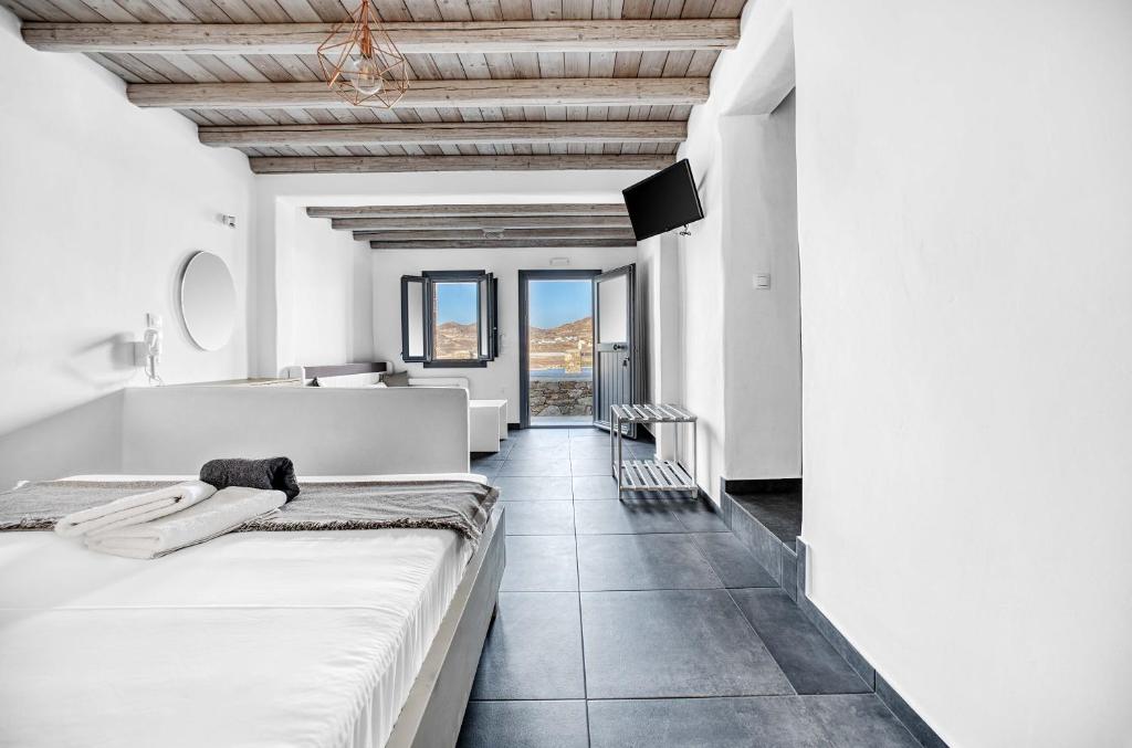 a bedroom with white walls and a large bed at Belvedere in Livadi