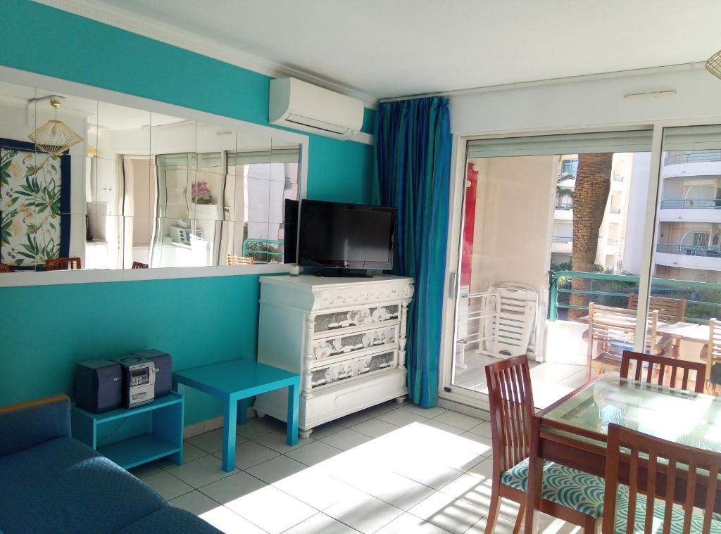 a living room with a television and a table and chairs at Résidence du Port - Borghese in Fréjus