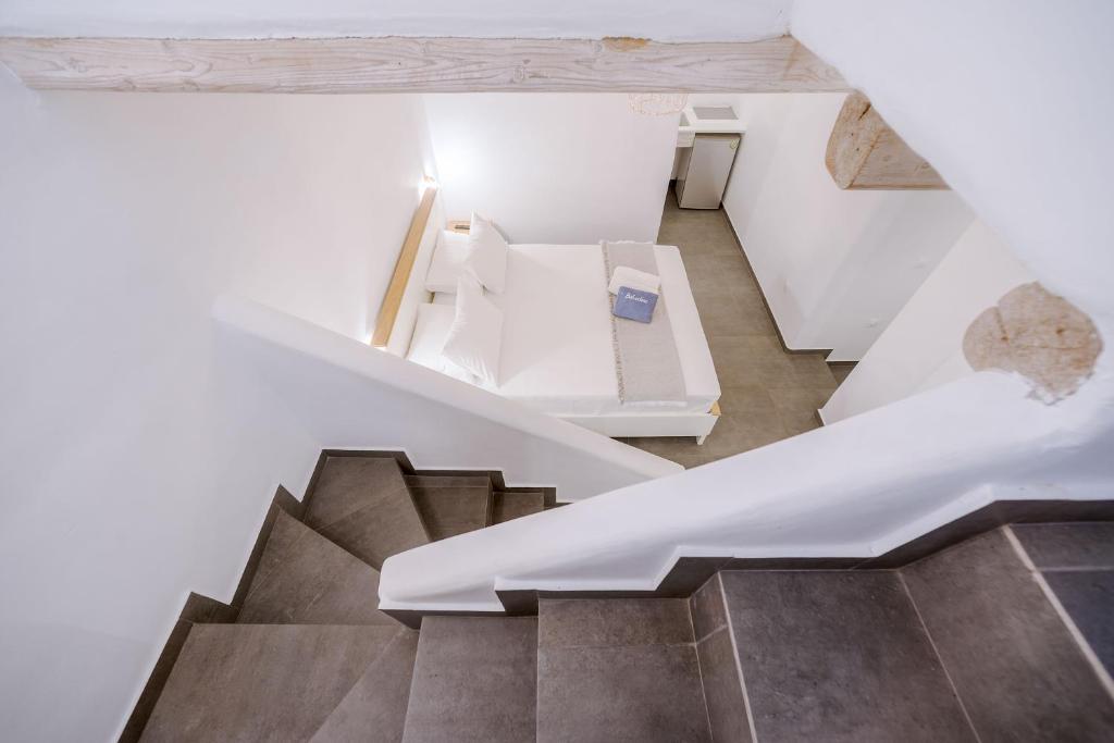 a staircase in a house with white walls and wooden ceilings at Belvedere in Livadi