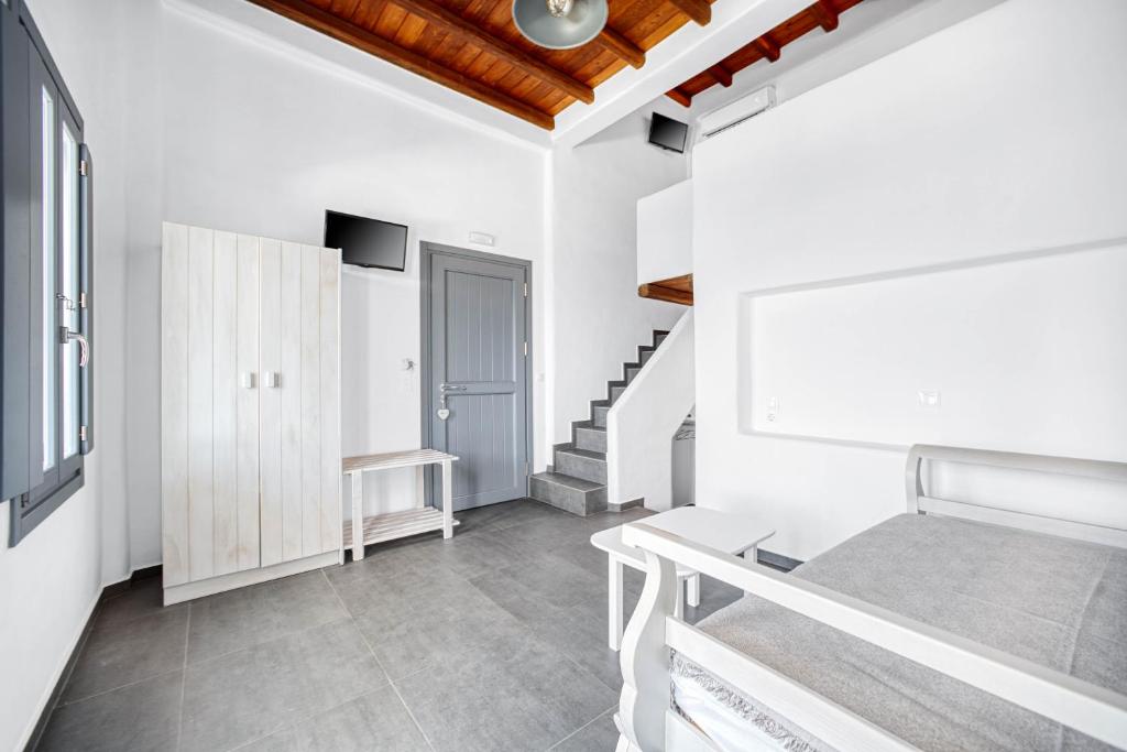 a white room with a staircase and a bed at Belvedere in Livadi