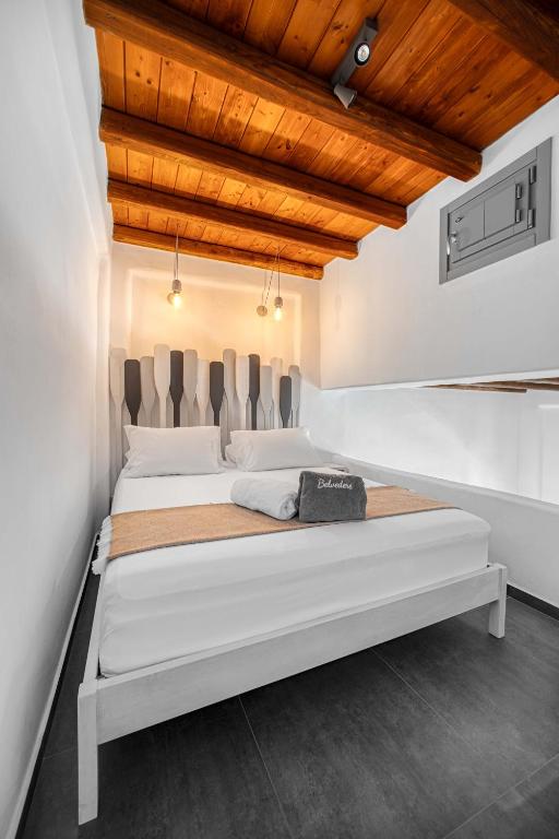 a large white bed in a room with wooden ceilings at Belvedere in Livadi