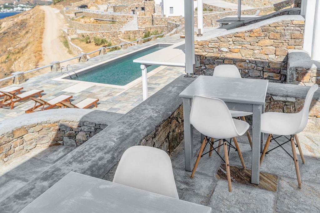 a table and chairs on a patio with a pool at Belvedere in Livadi