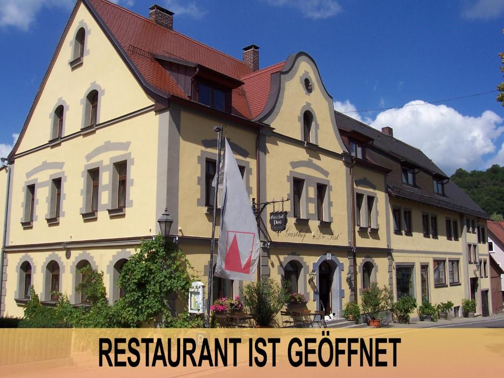 Schillingsfürst的住宿－Hotel-Gasthof Die Post Brennerei Frankenhöhe，前面有标志的建筑