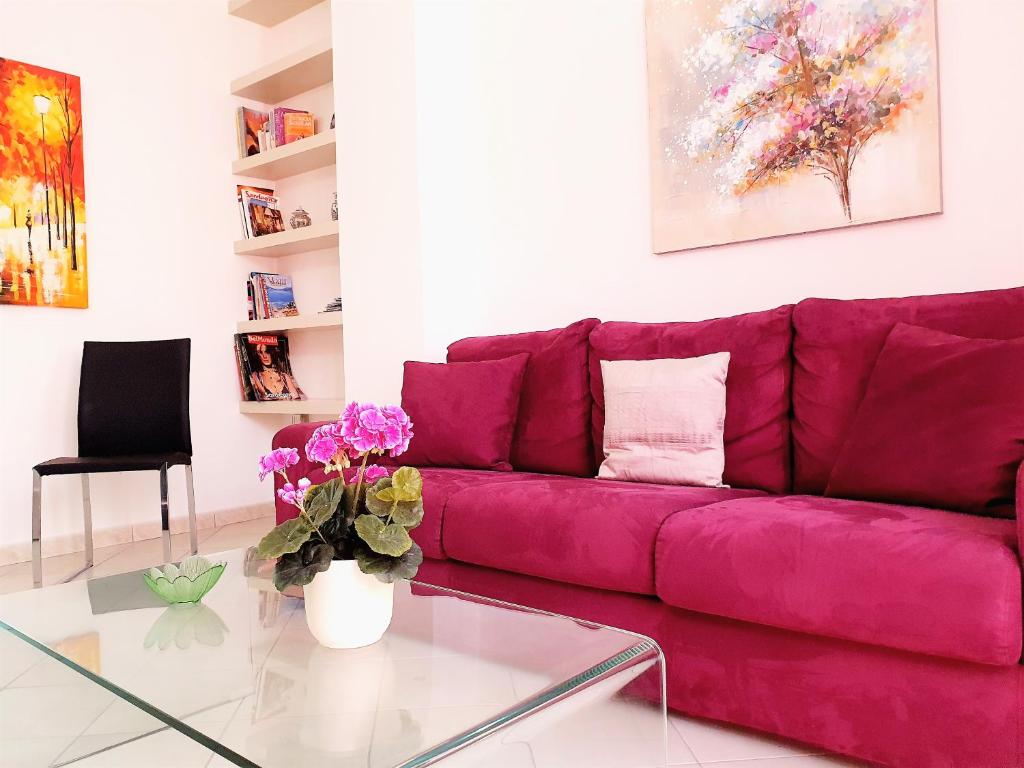 サンタンティーオコにあるIl Soleのガラステーブル付きのリビングルームに紫色のソファ