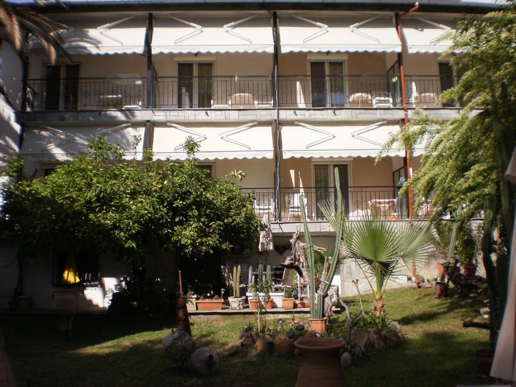 an apartment building with a courtyard with trees and plants at Studios Rosa in Agia Paraskevi