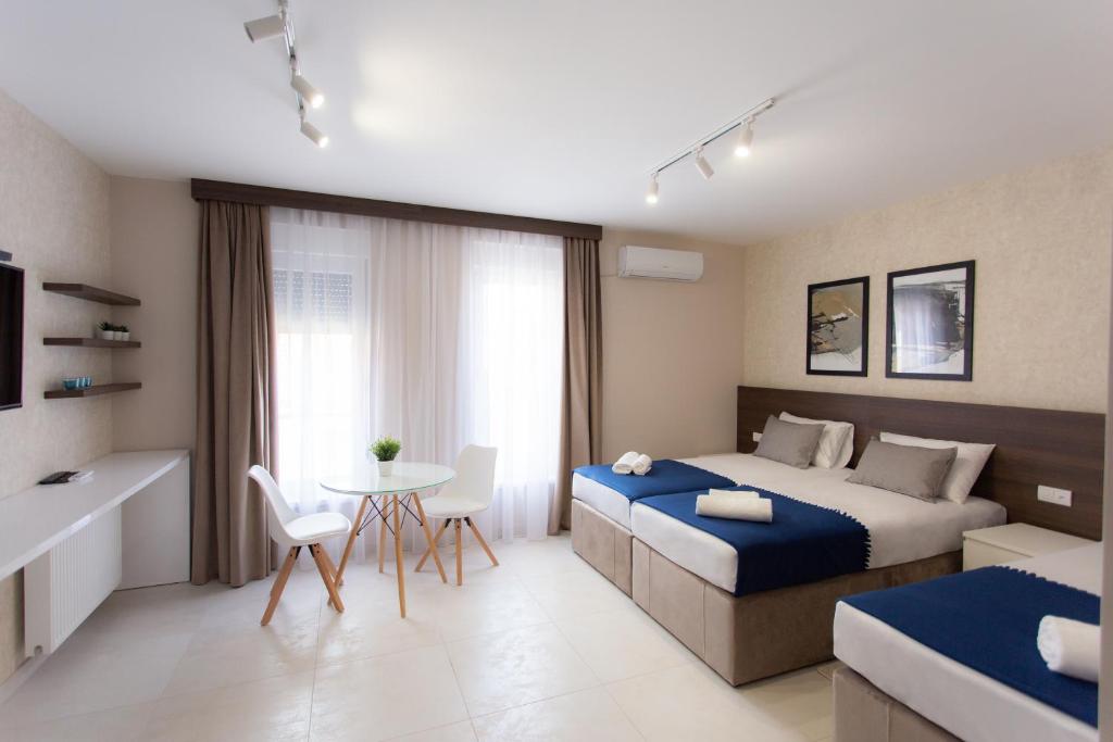 um quarto de hotel com uma cama, uma mesa e cadeiras em Villa BonnaDea em Valjevo