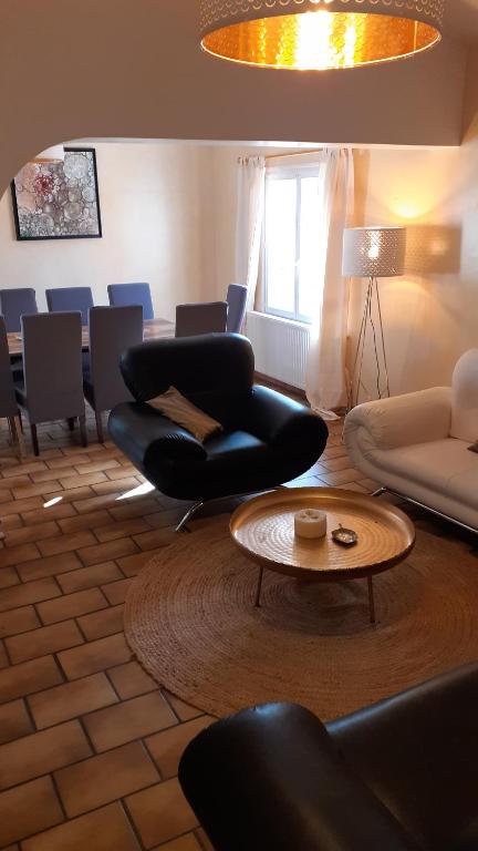 uma sala de estar com cadeiras pretas e uma mesa em L'Oustaou d'Aiglun em Aiglun