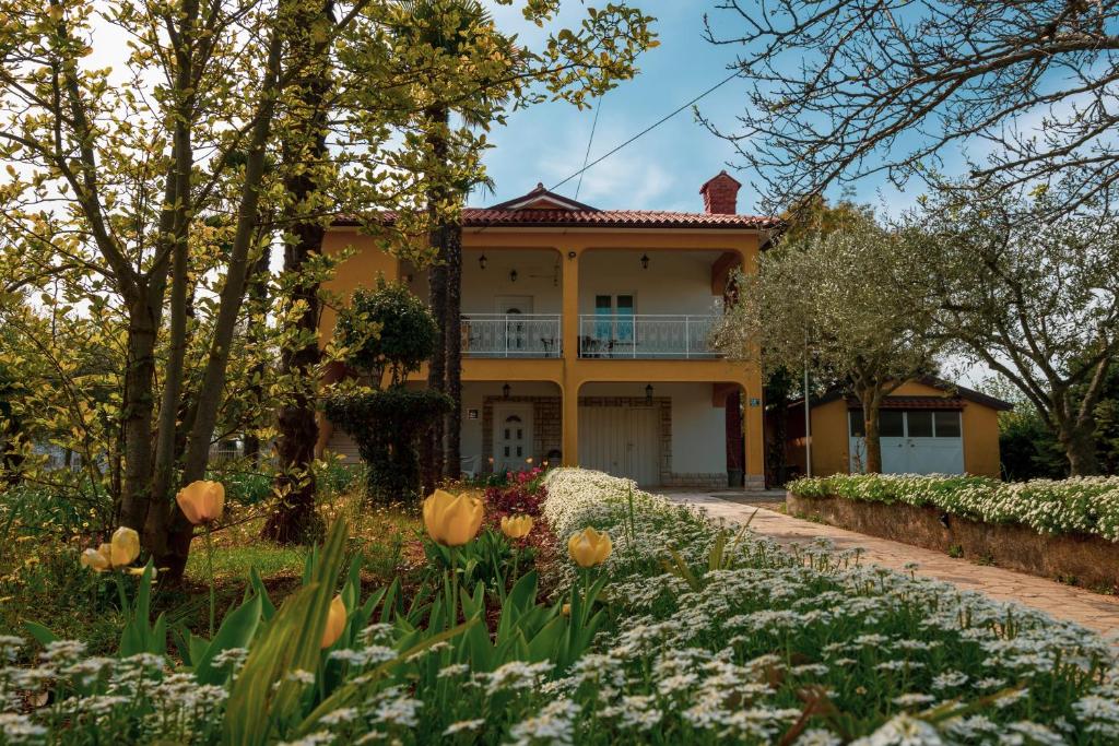 a house with a garden in front of it at Apartment Villa Olga in Poreč