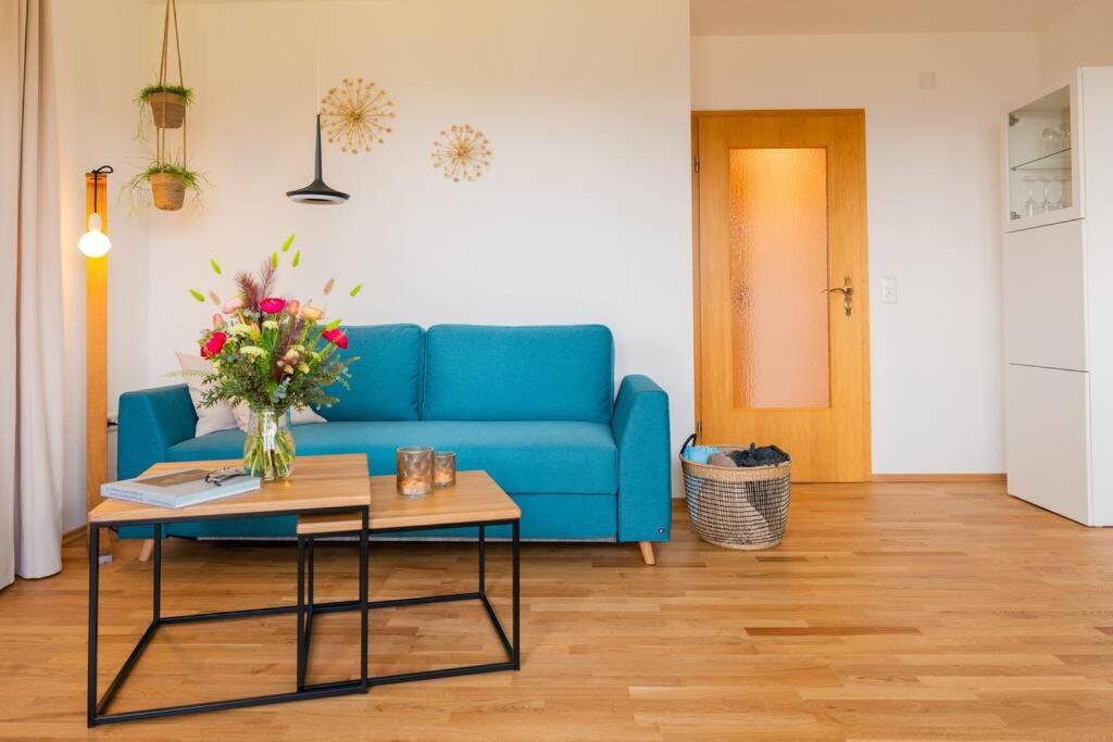 a living room with a blue couch and a table at Appartement Bergsonne in Sankt Märgen