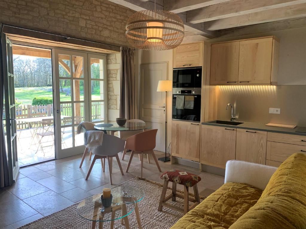 a kitchen and living room with a couch and a table at Manoir de Malagorse in Cuzance