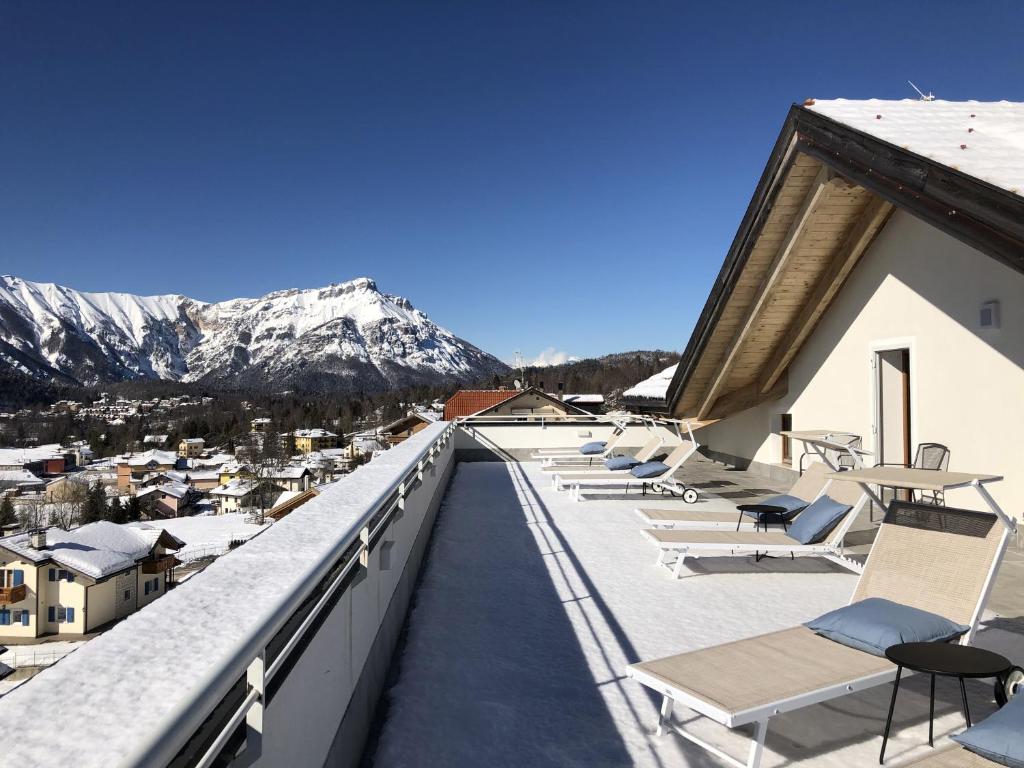 a balcony with chairs and mountains in the background at Residence Aurora in Lavarone