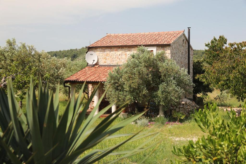 an old stone house with a bird on the roof at House Flamingo in Pašman