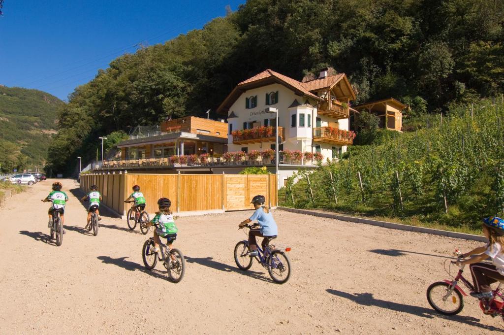 - un groupe d'enfants à vélo sur un chemin de terre dans l'établissement Ottenkellerhof, à Bolzano