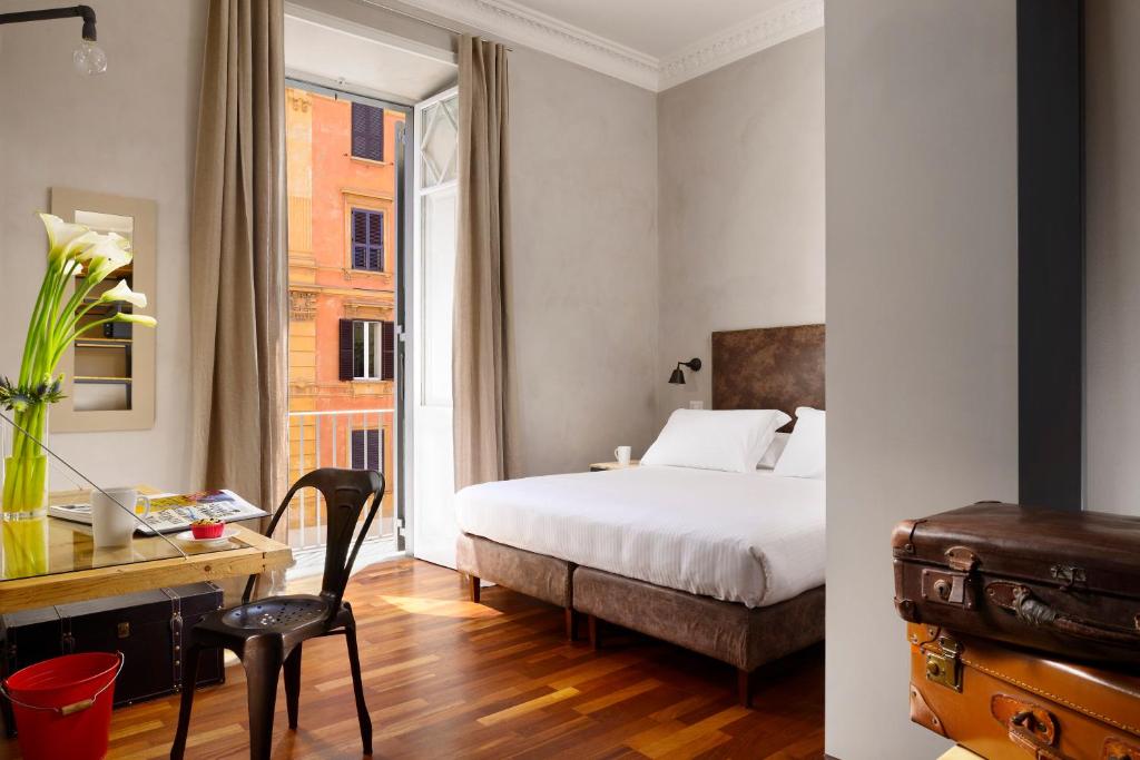 Schlafzimmer mit einem Bett, einem Schreibtisch und einem Fenster in der Unterkunft San Pietro Boutique Rooms in Rom