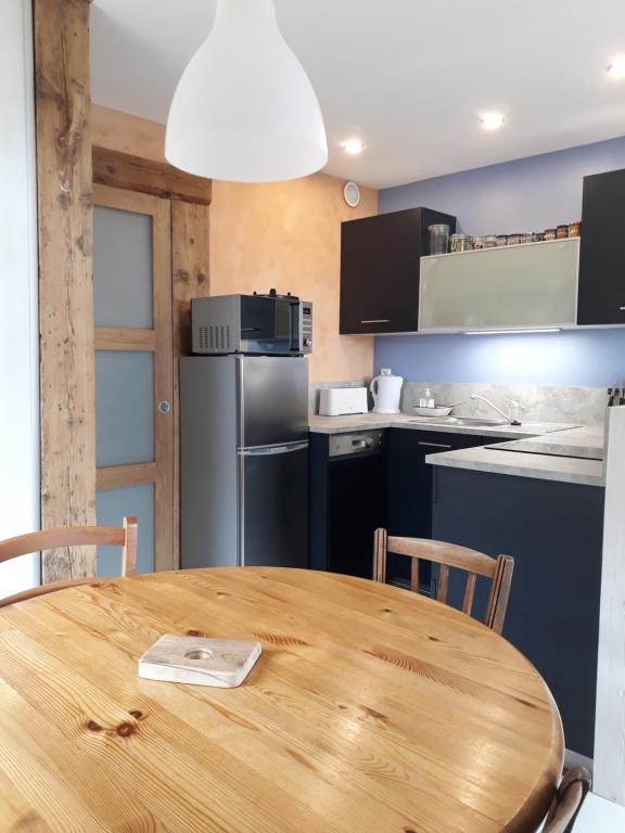 Plagne 1800にあるAppartement rez de jardin et garage privéのキッチン(木製テーブル、椅子付)、ダイニングルーム