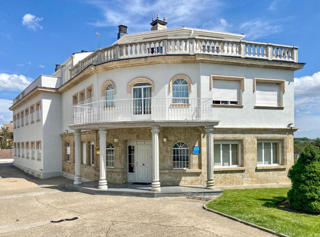 uma grande casa branca com uma varanda em cima em Casablanca Hotel Studios em Santa Marta de Tormes