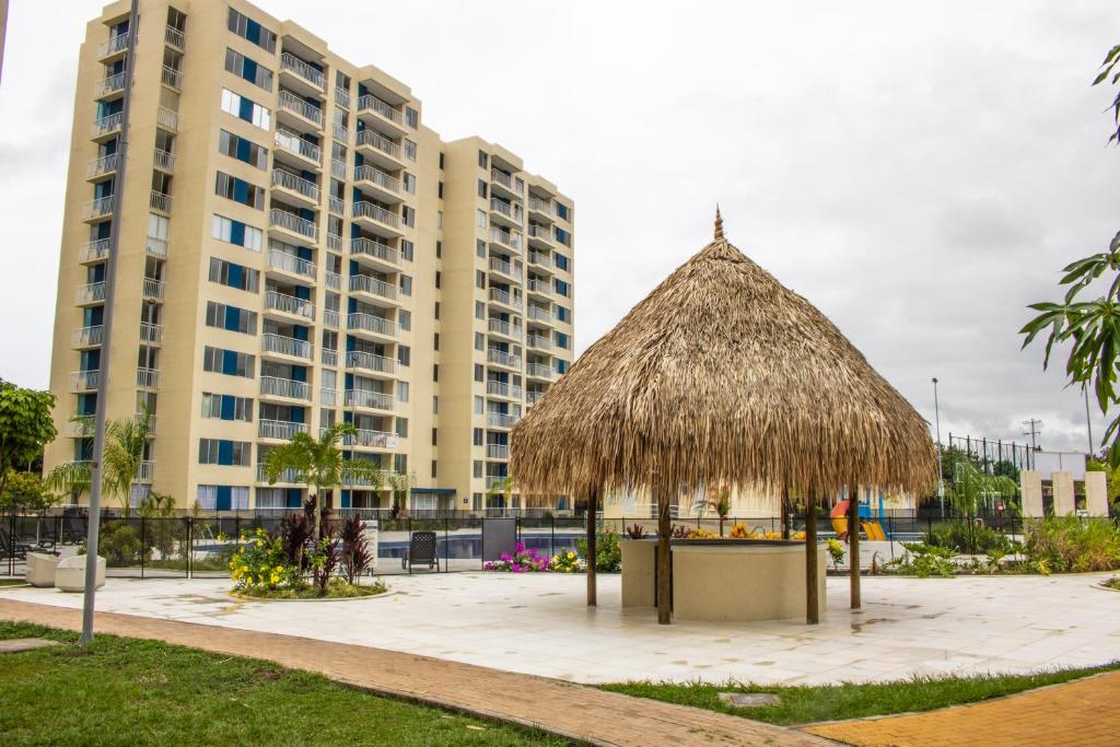 a straw hut in front of a building at Puerto Azul Club House in Ricaurte