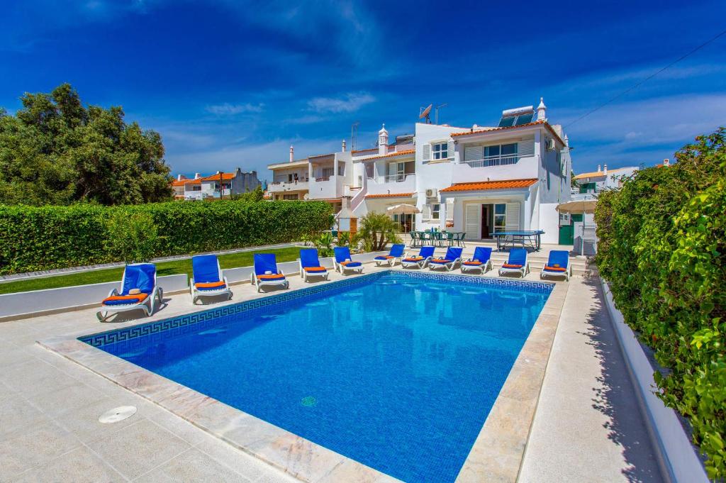 una piscina con tumbonas y una casa en Villa Animado by Villa Plus, en Albufeira