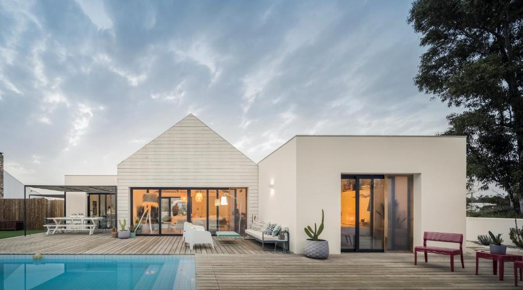 uma casa branca com uma piscina em frente em Manos 114 na Comporta