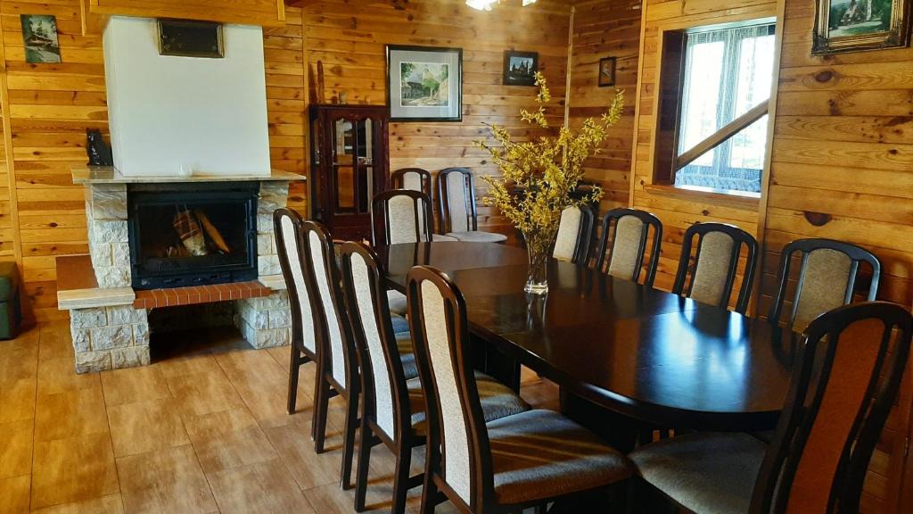 a dining room with a table and a fireplace at Chata Górska Sowa dla 12 osób, 4 sypialnie,salon z kominkiem in Podgórzyn