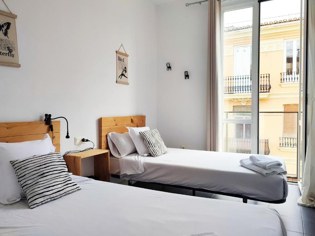 dwa łóżka w pokoju z oknem w obiekcie Flats Friends Torres Quart w Walencji