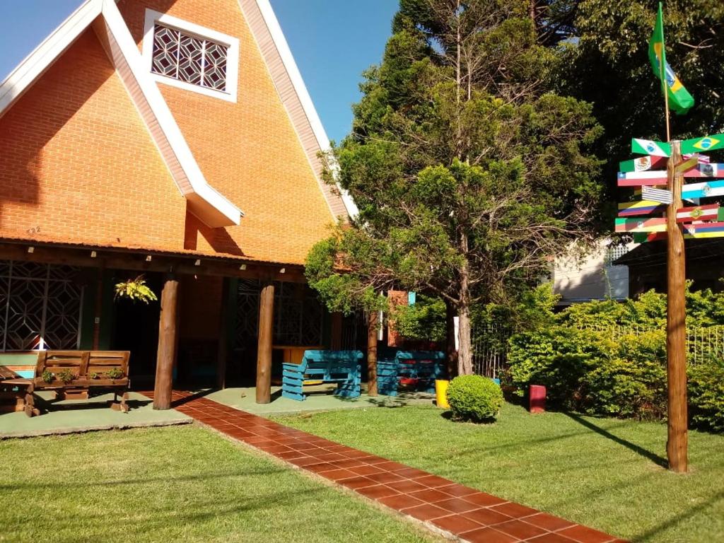 un edificio con un banco y un árbol en el patio en Hotel Veritas, en Guarapuava