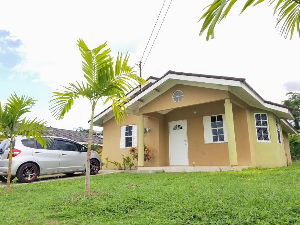 a house with a car parked in front of it at Tropix Villa in Mammee Bay