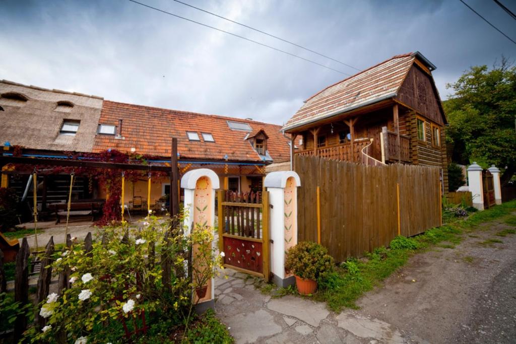 ein Haus mit einem Holztor und einem Zaun in der Unterkunft Penzión Starý Hostinec in Banská Štiavnica