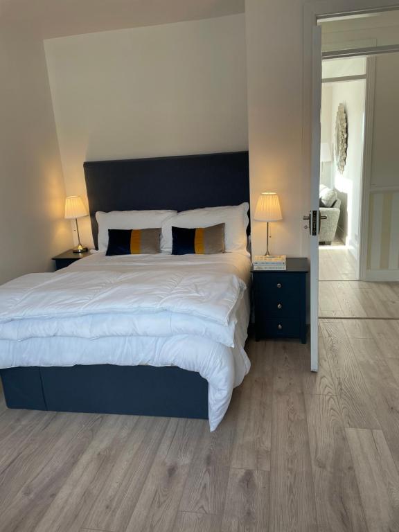 a bedroom with a large bed with a blue headboard at Stay Skelligs in Portmagee