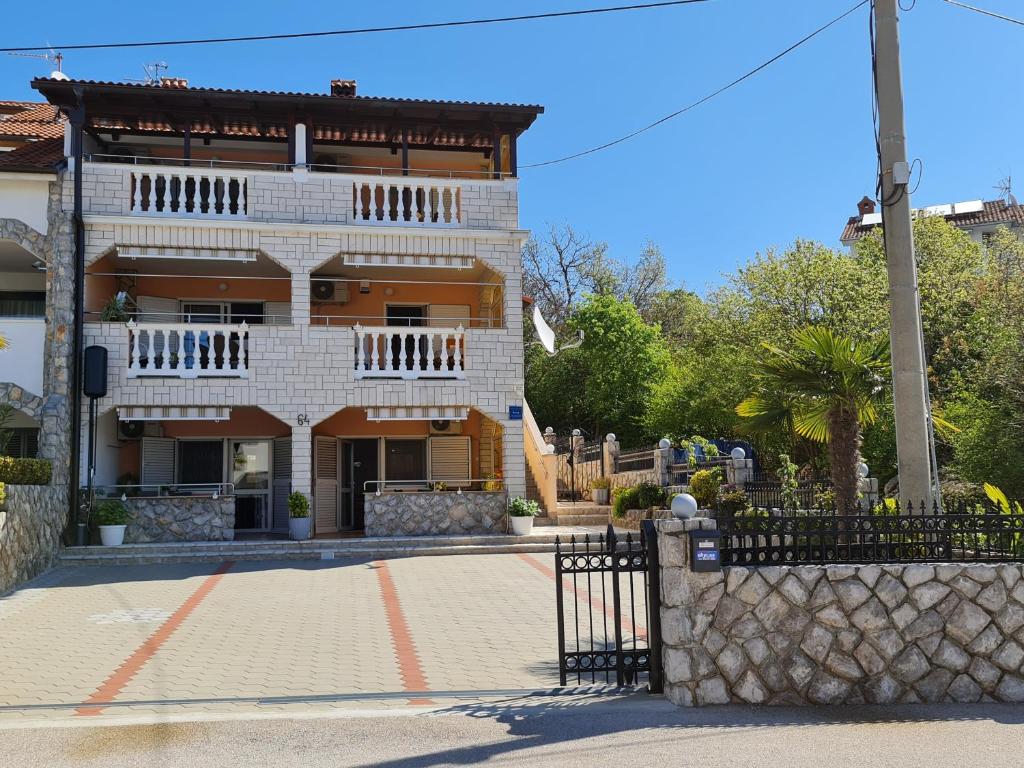 a building with a fence in front of it at Apartments NEF in Pinezici