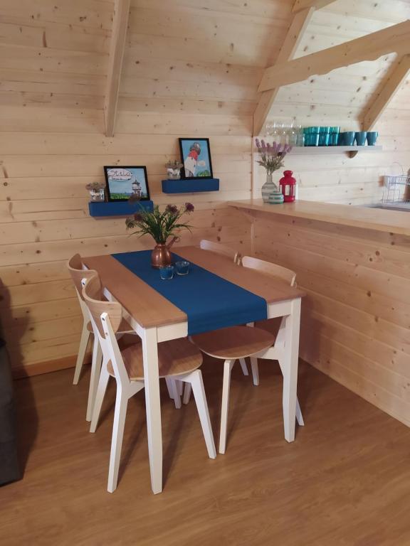a dining room with a table and chairs in a cabin at Domek letniskowy in Sasino