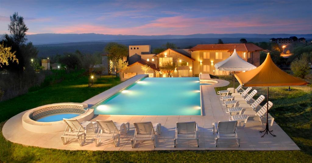 貝爾格拉諾將軍別墅的住宿－拉索納達旅館，一个带椅子的游泳池和一个泳池景