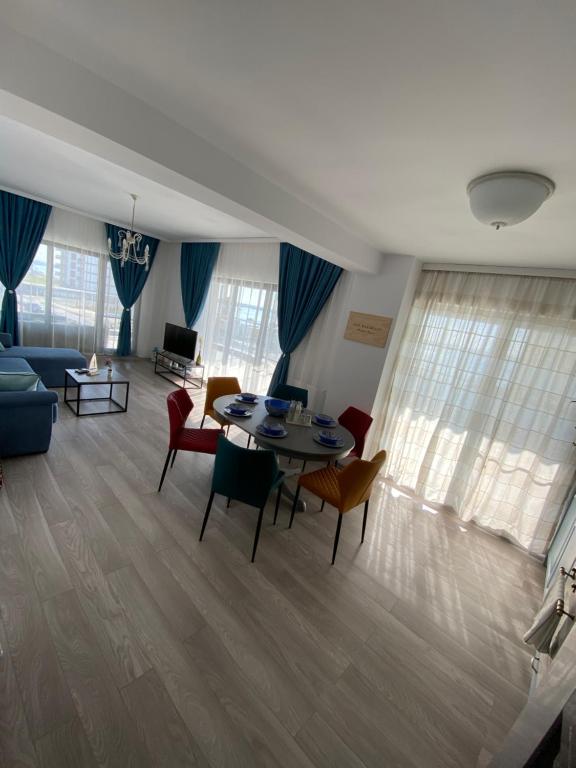- un salon avec une table et des chaises dans l'établissement Seafront Mamaia - Casa Del Mar Residence, à Mamaia
