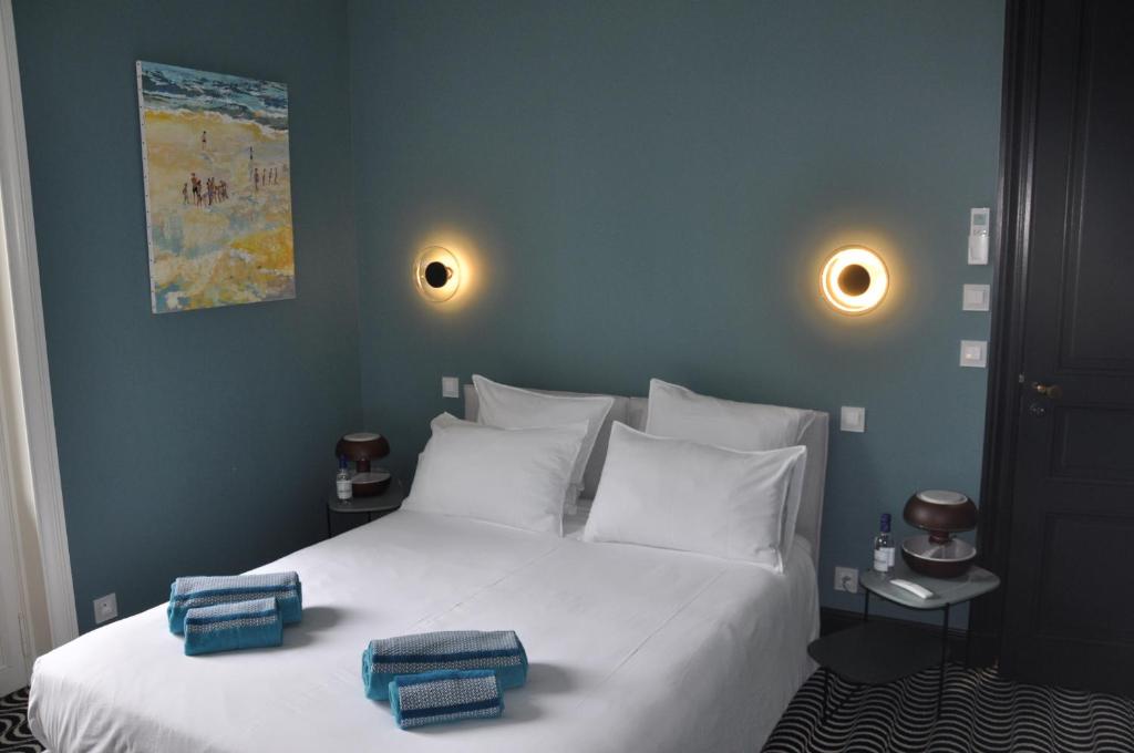 a bedroom with a white bed with two towels on it at Les Villas de la Ville d'Hiver Palissy in Arcachon