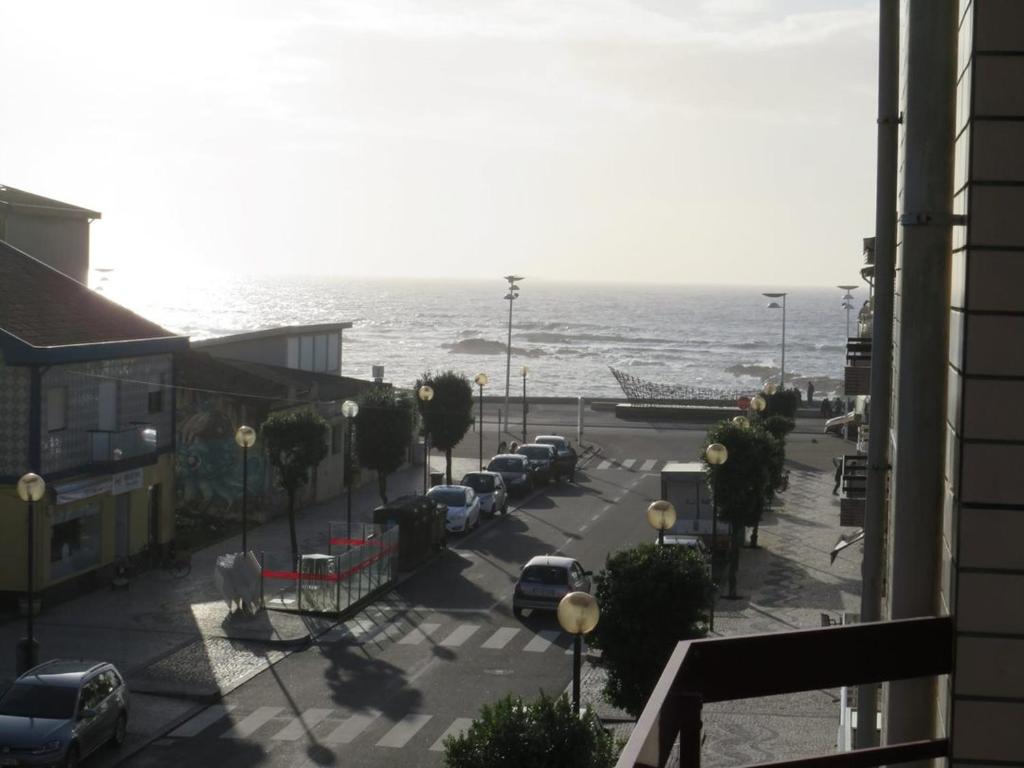 una vista de una calle con coches estacionados junto al océano en apartamento Vila do Conde, en Vila do Conde