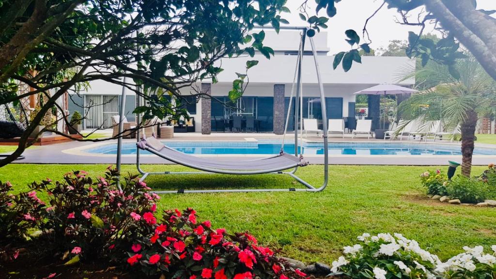 a swing in a yard next to a swimming pool at Luxury Chaves Village in Farroupo
