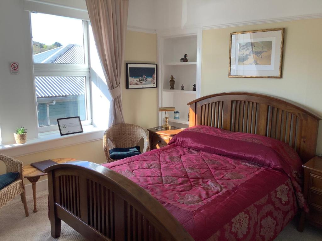 a bedroom with a large bed and a window at Struan House B&B in Tarbert