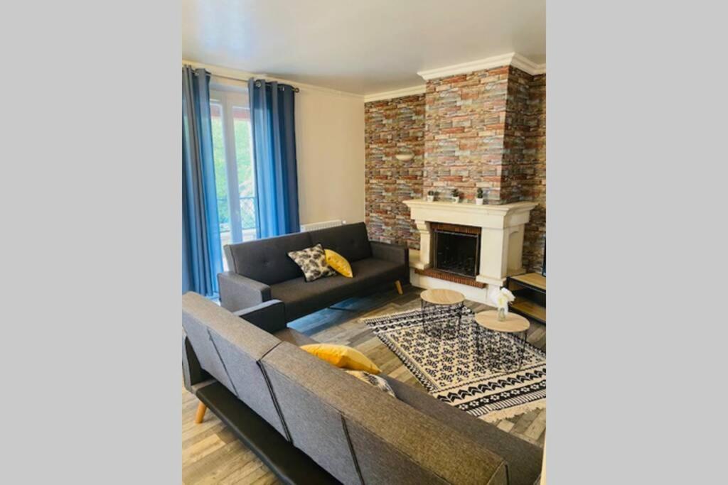 sala de estar con sofá y chimenea en Bel Appartement calme dans villa Provençale, en Montboucher-sur-Jabron