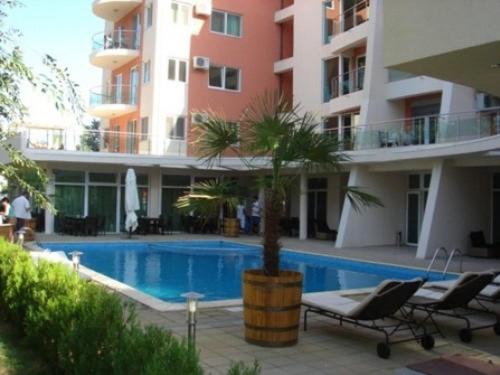 a hotel with a palm tree next to a swimming pool at apartament PIANO in Mamaia
