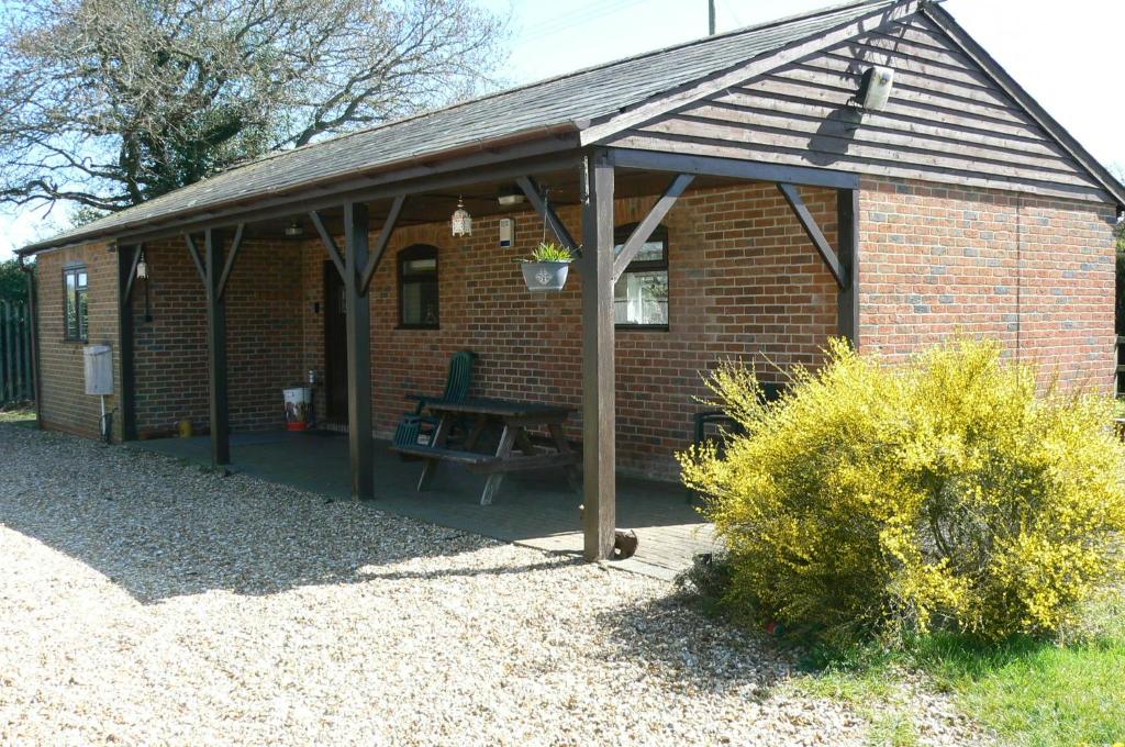 a brick house with a picnic table in front of it at Swallows Retreat in Fordingbridge