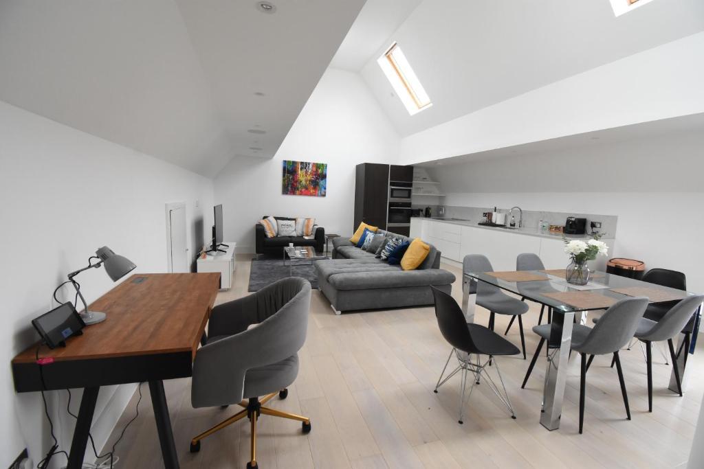 uma sala de estar com um sofá, uma mesa e cadeiras em Northside Apartments Ealing em Londres