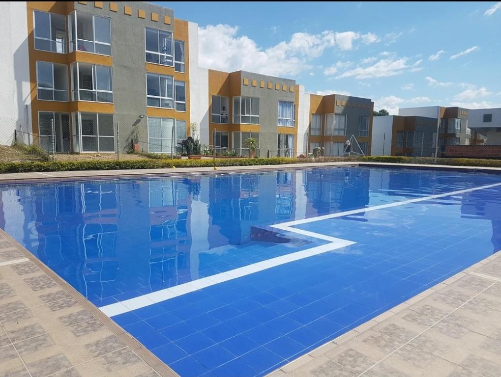 a large blue swimming pool in front of a building at Apto Moderno Sta Rosa de Cabal (termales) in Santa Rosa de Cabal