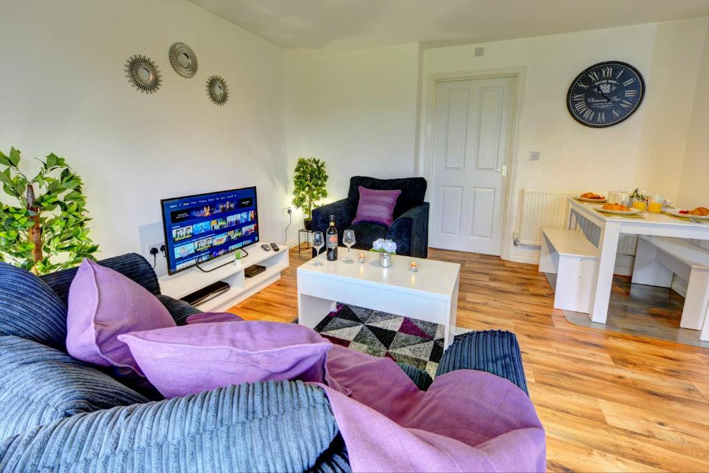 a living room with a couch and a tv at 2-BR Apartment, En-suite, Allocated Parking, next to Playground in Coventry