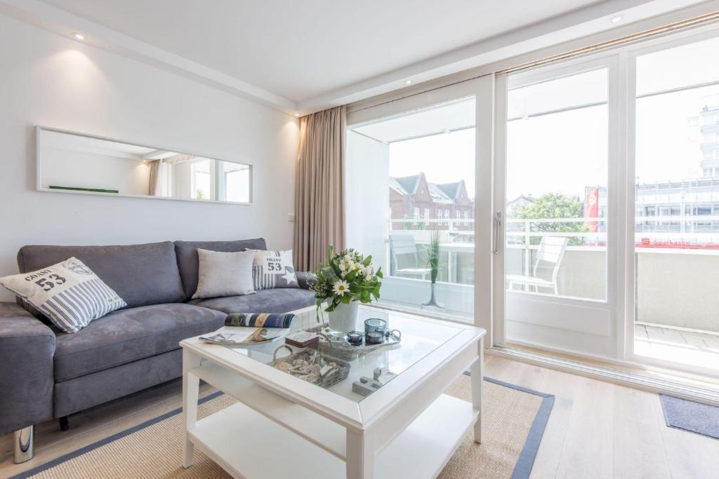 uma sala de estar com um sofá e uma mesa em Hanseatenhaus Whg 1 em Westerland