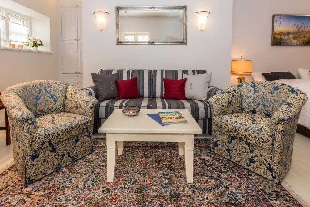ein Wohnzimmer mit 2 Stühlen und einem Sofa in der Unterkunft Villa Maybach Whg 3 in Westerland