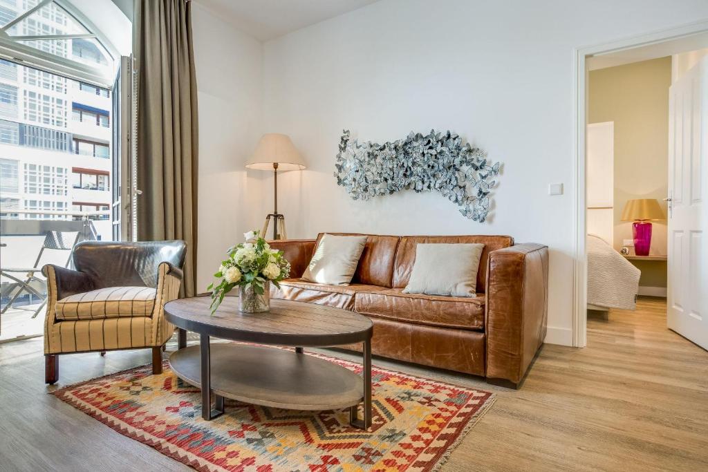 ein Wohnzimmer mit einem braunen Sofa und einem Tisch in der Unterkunft Art your Life Residenz Seeburg Whg 8 in Westerland