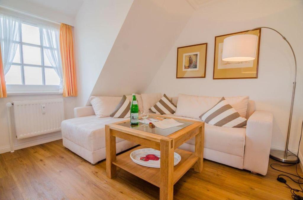 a living room with a white couch and a table at Haus Heefkant Whg 10 in Rantum