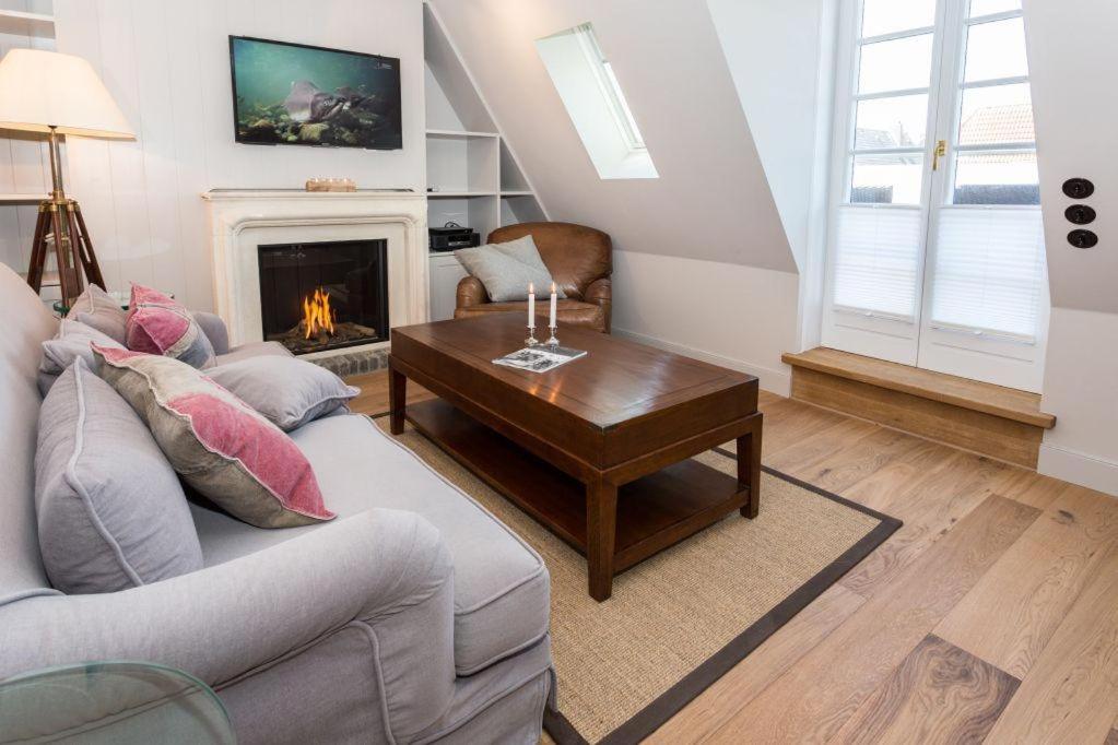 a living room with a couch and a fireplace at Villa Aegir Whg 2 in Westerland